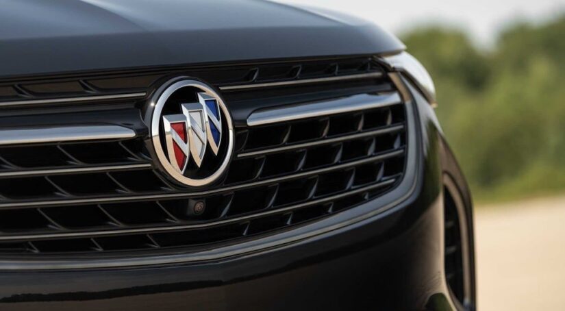 A close-up on the grille of a black 2024 Buick Envision GT is shown.