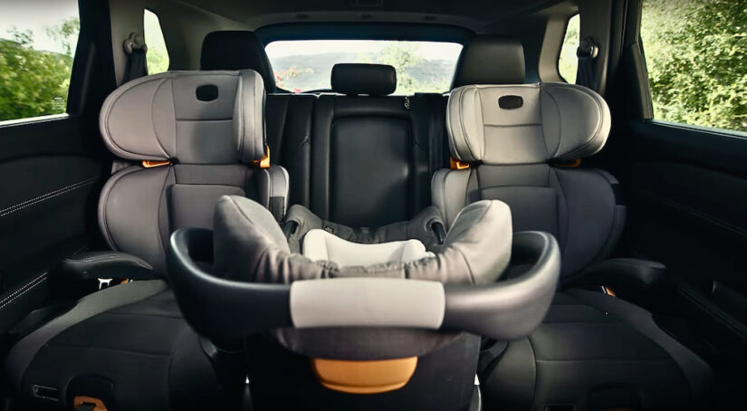 The interior of a 2024 Nissan Rogue with three carseats strapped in.