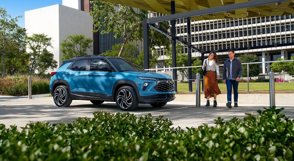 A blue 2025 Chevy Trailblazer RS is shown parked near a Chevy dealer.