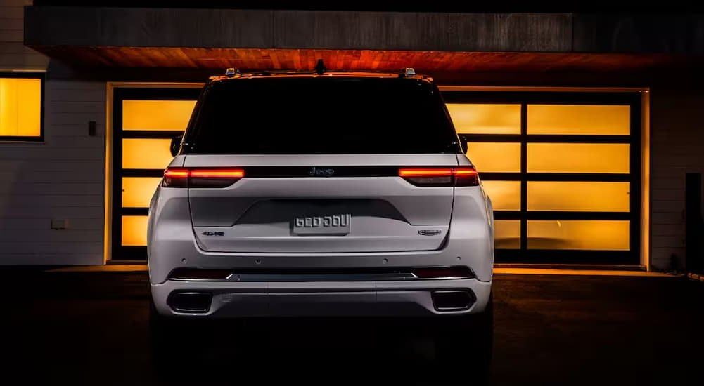 The rear-end view of a white 2025 Jeep Grand Cherokee is shown.