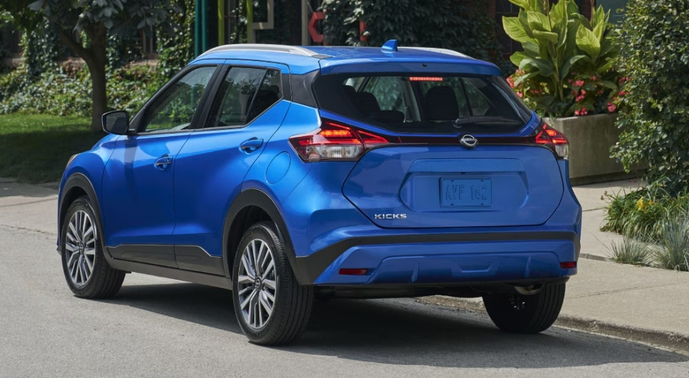 A blue 2025 Nissan Kicks Play is shown from the rear at an angle.