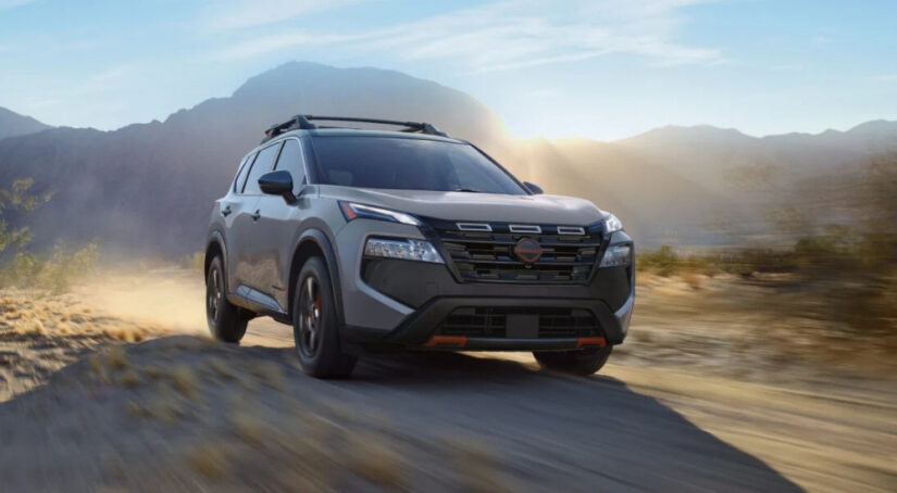 A grey 2025 Nissan Rogue Rock Creek is shown from the front at an angle after leaving a Nissan dealer near me.