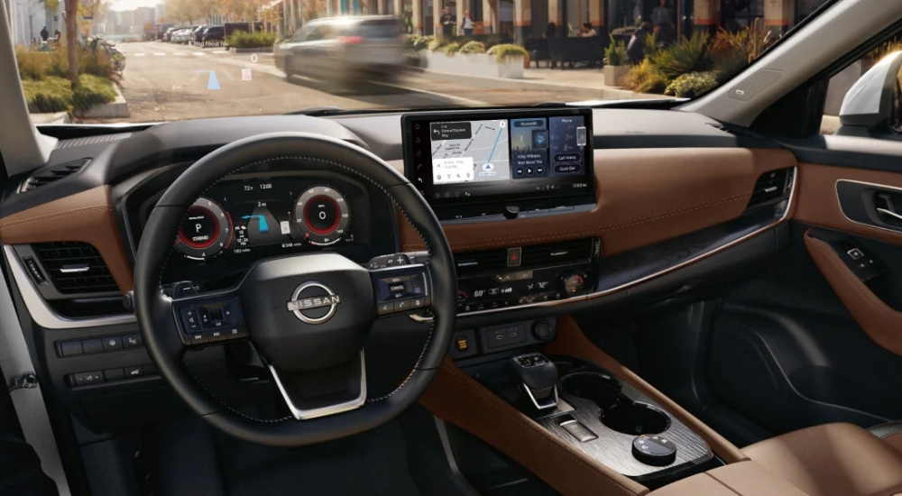 The brown interior of a 2025 Nissan Rogue is shown from the driver's seat.