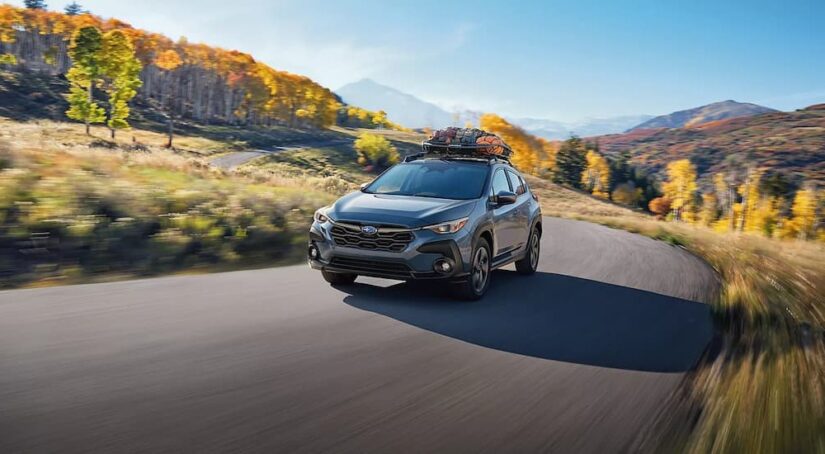 A gray 2025 Subaru Crosstrek Premium is shown driving to view a Subaru Crosstrek for sale.