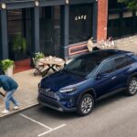 A blue 2025 Toyota RAV4 is shown parked after visiting a Toyota dealer.
