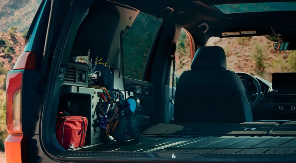 The rear cargo area is shown in an orange 2026 Honda Passport TrailSport Elite.