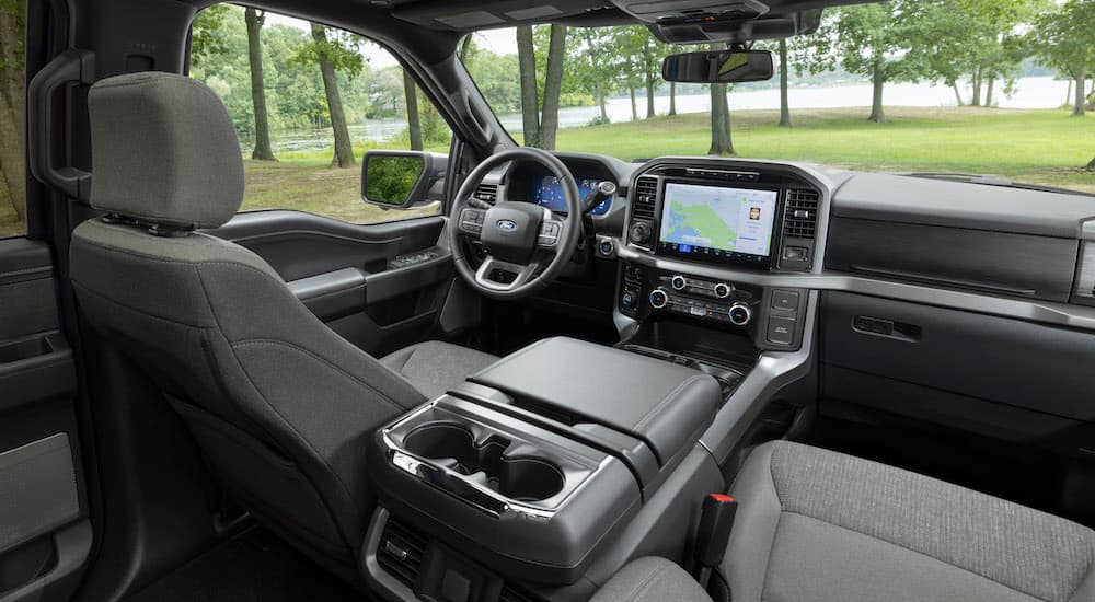 The grey interior of a 2024 Ford F-150 XLT is shown from the rear seats.