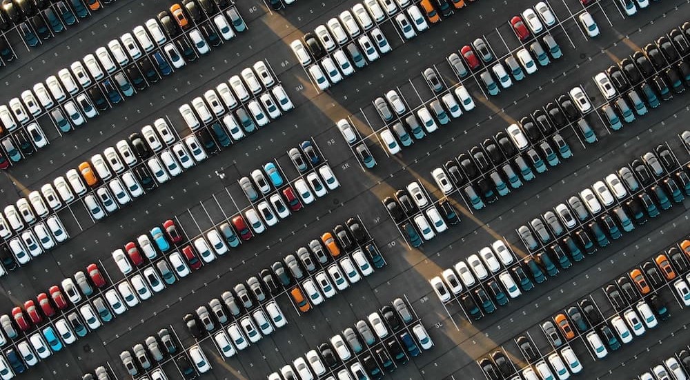 An aerial view is shown of a parking lot full of vehicles.