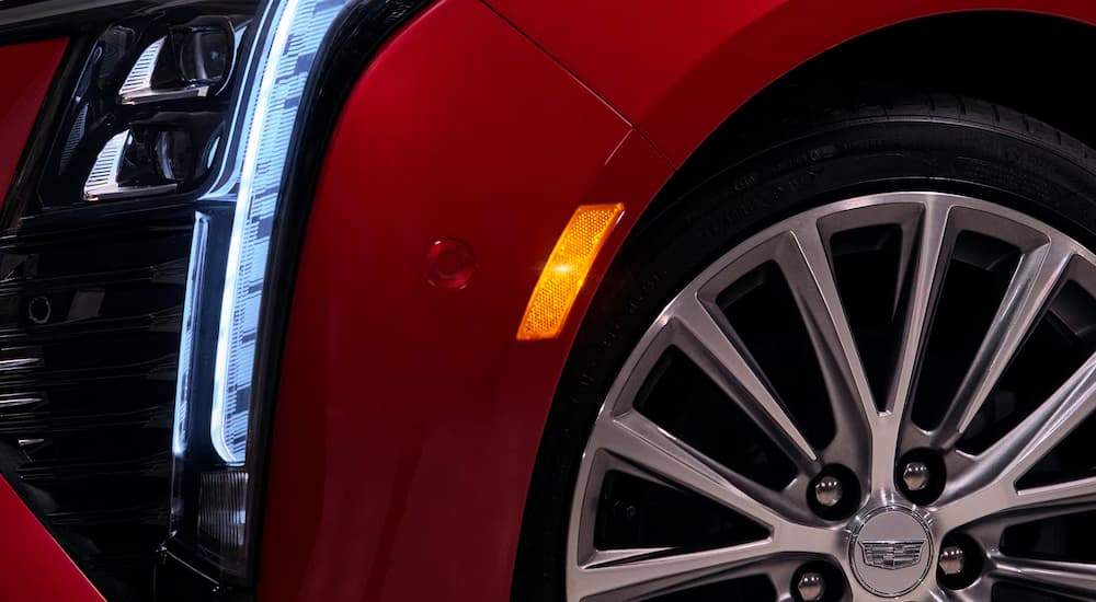 A close up of the wheel and rim on a red 2025 Cadillac CT5 for sale.