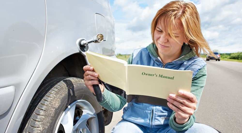 A person is shown reading an owner's manual.