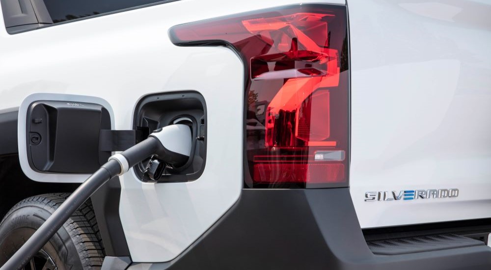 Close-up on the charging port of a white 2025 Chevy Silverado EV WT.