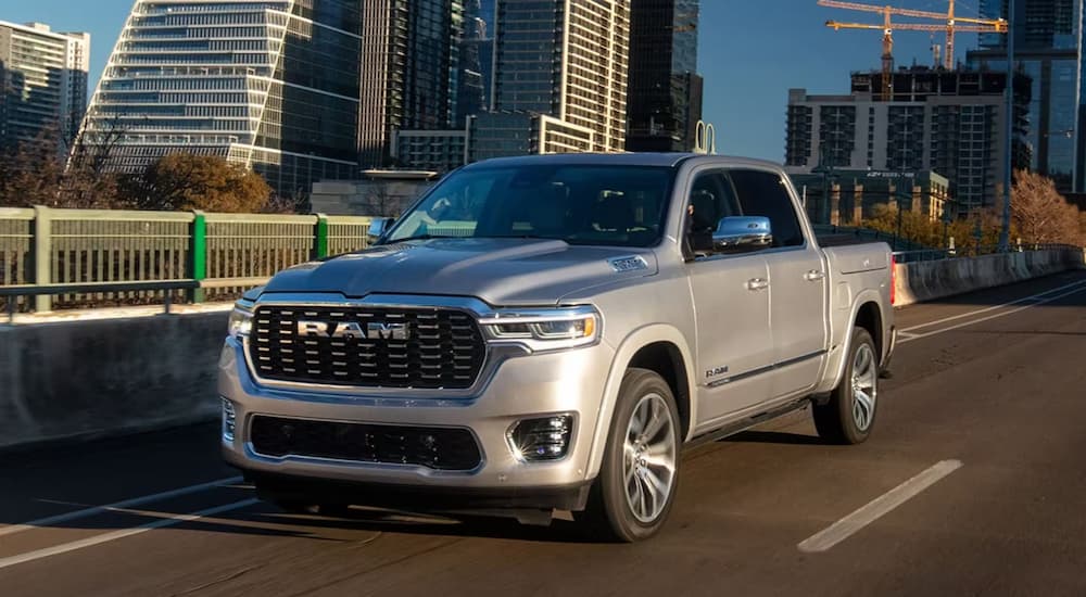 A grey 2025 Ram 1500 Tungsten driving through a city.