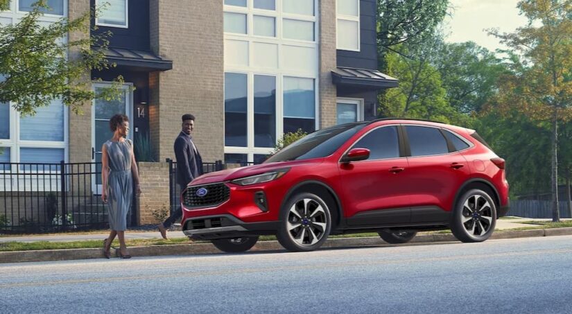 A red 2025 Ford Escape Platinum is shown parked on a city street.