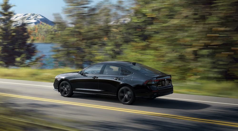 A black 2025 Honda Accord Hybrid is shown from the side.