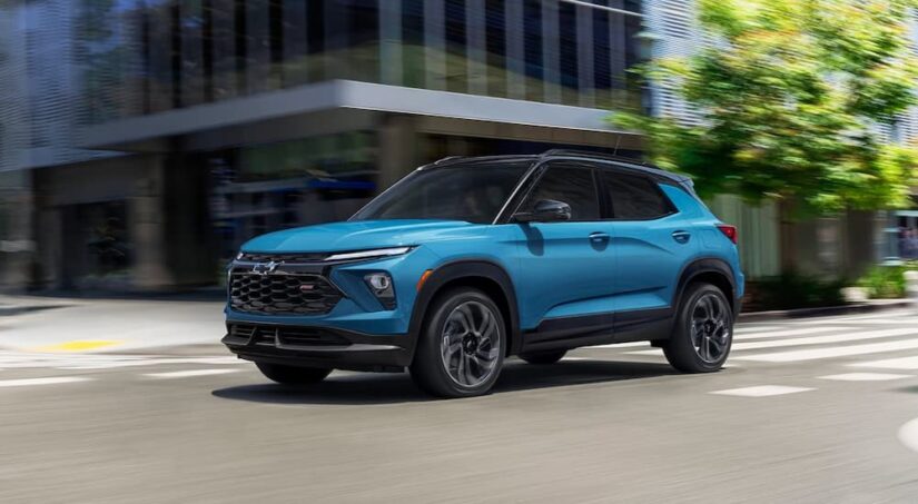 A blue 2025 Chevy Trailblazer RS is shown driving on a city street.