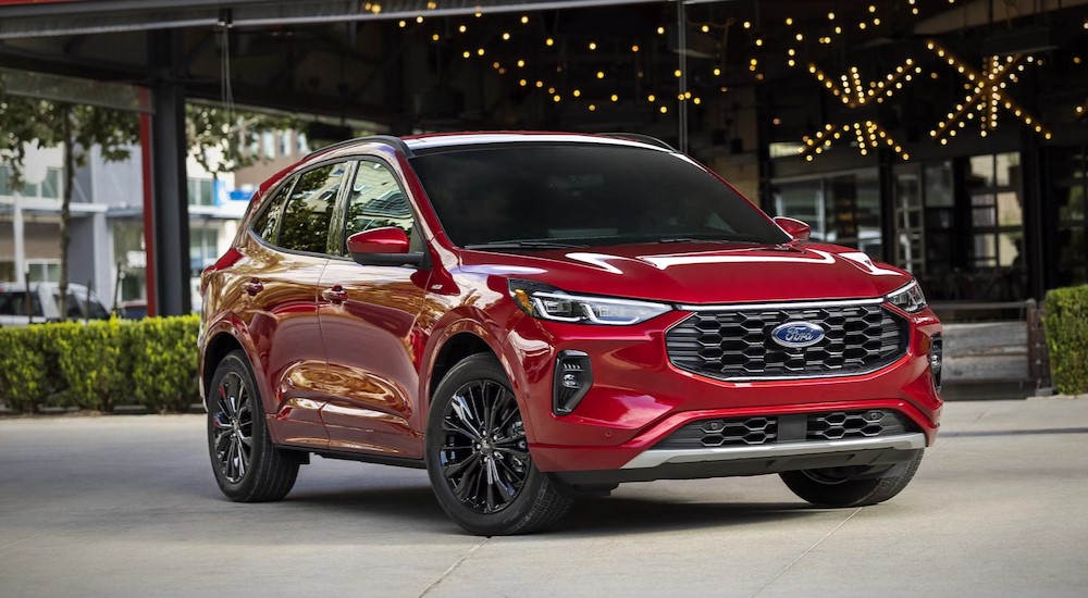 A red 2025 Ford Escape PHEV is shown parked near bushes.