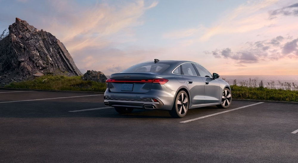 A silver 2025 Audi A5 is shown from the rear at dusk.