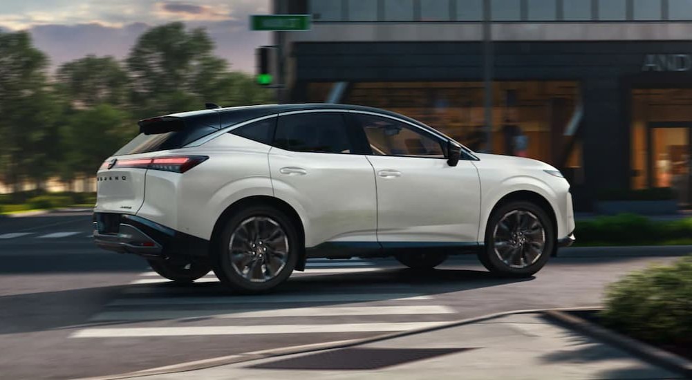 A white 2025 Nissan Murano Platinum is shown turning onto a city street.