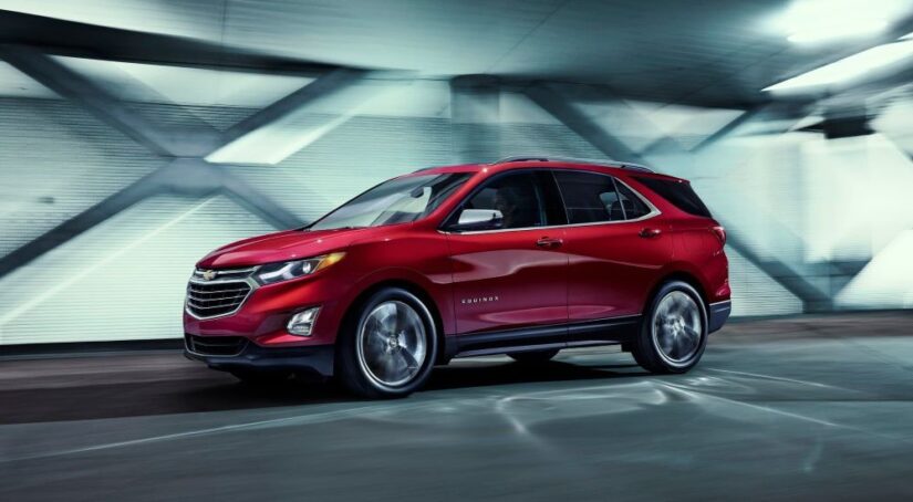 A red 2018 Chevy Equinox is shown driving in a tunnel after viewing a used Chevy Equinox for sale.