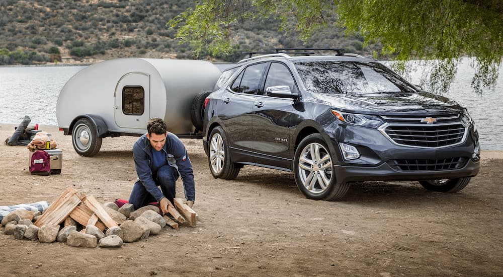 A gray 2020 Chevy Equinox is shown parked on a campsite.