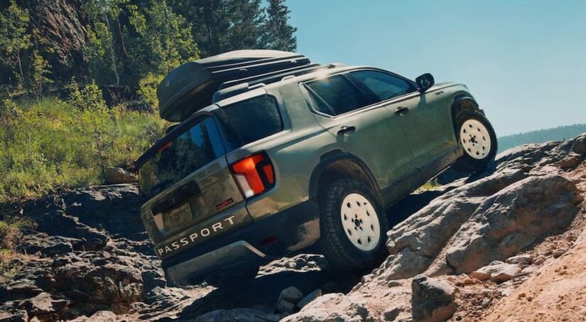 A green 2026 Honda Passport for sale is shown off-roading.