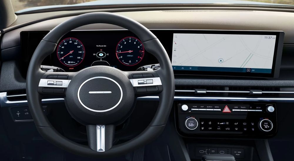 Close-up of the steering wheel and panoramic infotainment screen in a 2025 Hyundai Santa Cruz for sale.