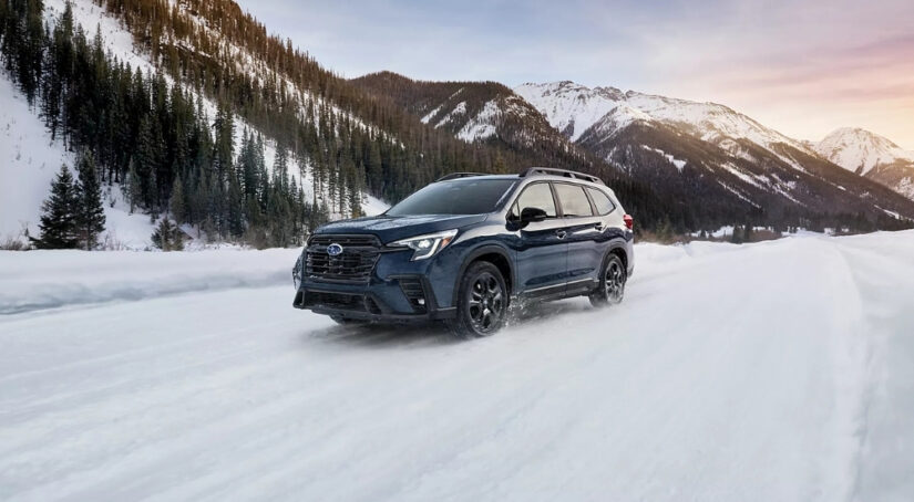 A blue 2025 Subaru Ascent for sale is shown on a snowy trail.