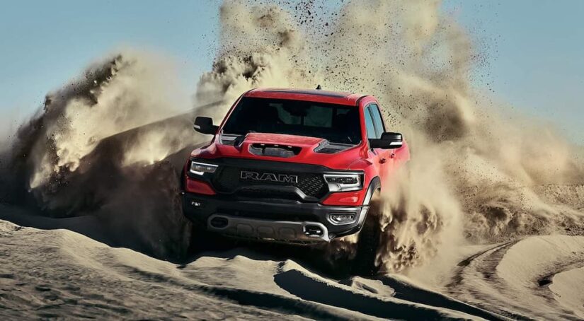 A red 2021 Ram 1500 TRX is shown off-roading after viewing used trucks for sale.