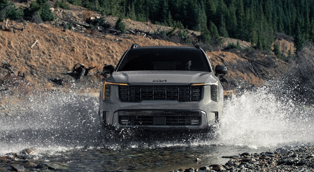A grey 2025 Kia Sorento driving through water.