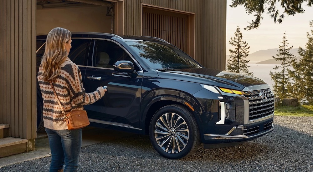 A blue 2025 Hyundai Palisade pulling out of a garage.