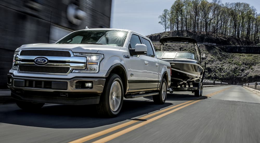 A white 2020 Ford F-150 towing a boat