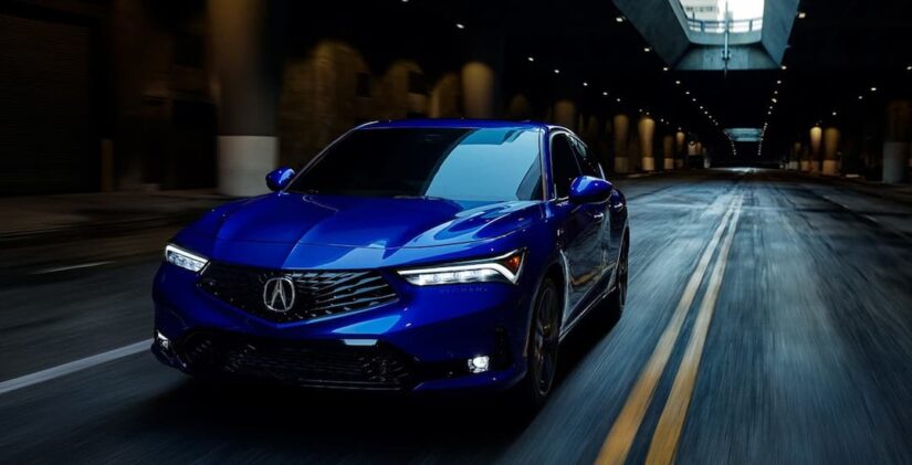 A blue 2025 Acura Integra hatchback driving in a tunnel.
