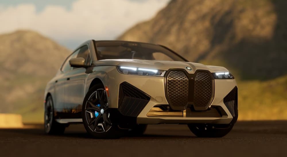 A silver 2025 BMW iX parked on a sunny day.