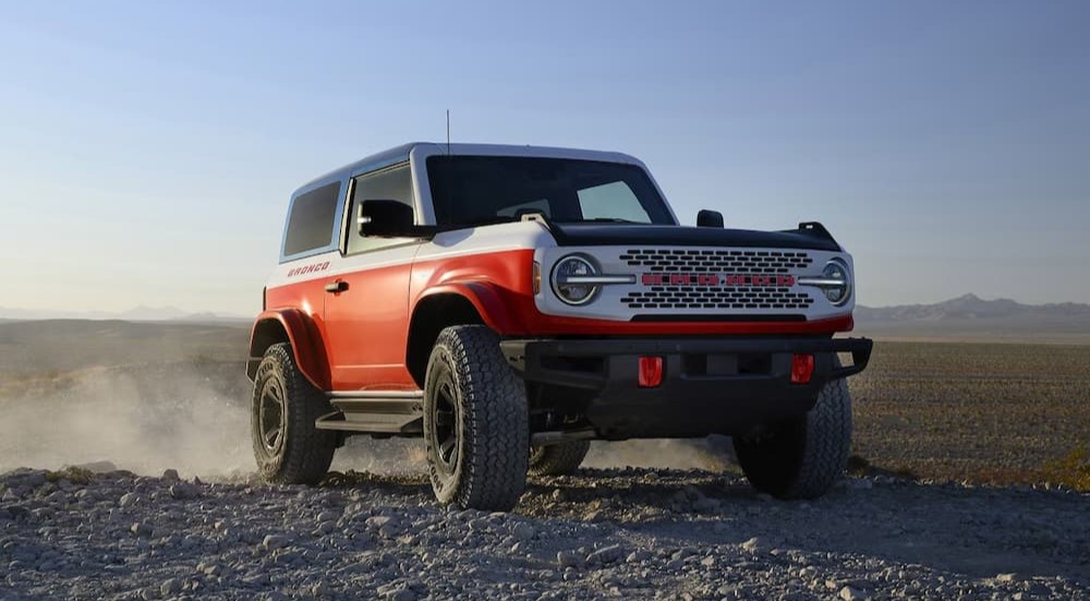 A red 2025 Ford Bronco Stroppe Edition is shown kicking up dust off-road.