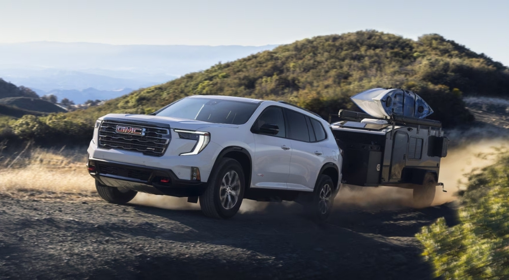 White 2025 GMC Acadia AT4 towing a trailer