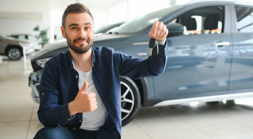 A person holds keys to their new car.