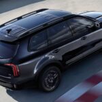 Black 2025 Kia Telluride driving on a track.