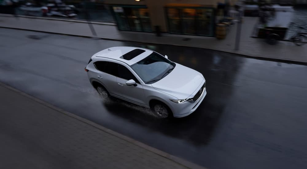 A white 2025 Mazda CX-5 driving down the street