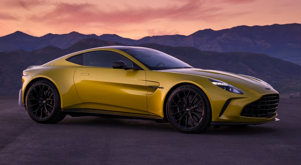 A yellow custom Aston Martin Vantage parked off-road