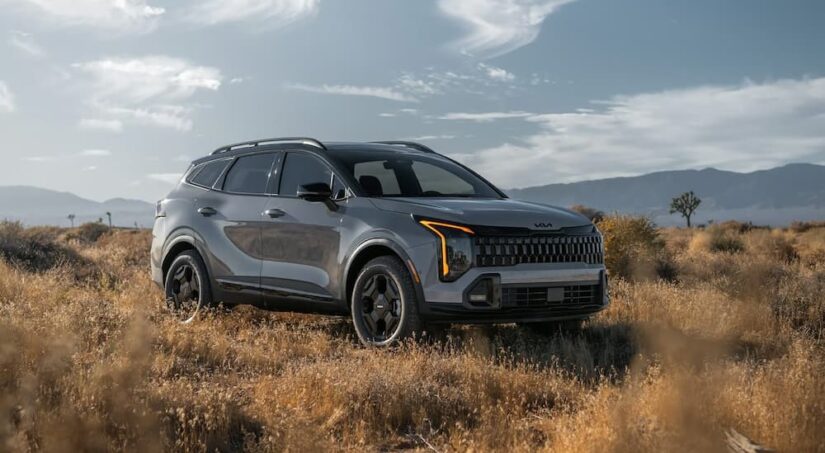 A gray 2026 Kia Sportage for sale parked in a field.