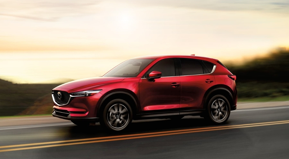 A red 2017 Mazda CX-5 driving on a highway.