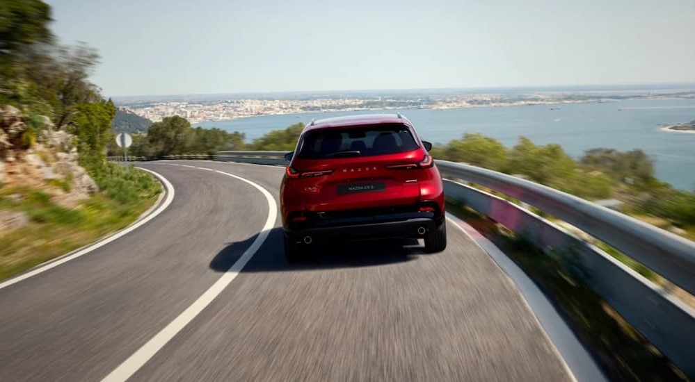 A red 2026 Mazda CX-5 driving on a highway.