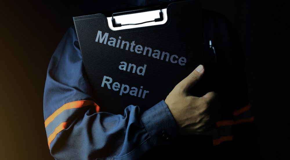 A technician holding a maintenance and repair report.