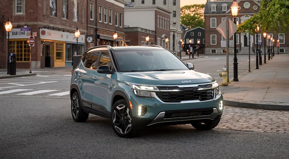 A blue 2025 Kia Seltos driving in a city.