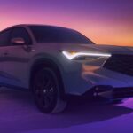 A gray 2025 Acura ADX parked off-road at night