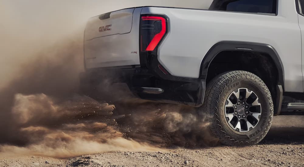 A gray 2026 Sierra EV AT4 off-roading on sand
