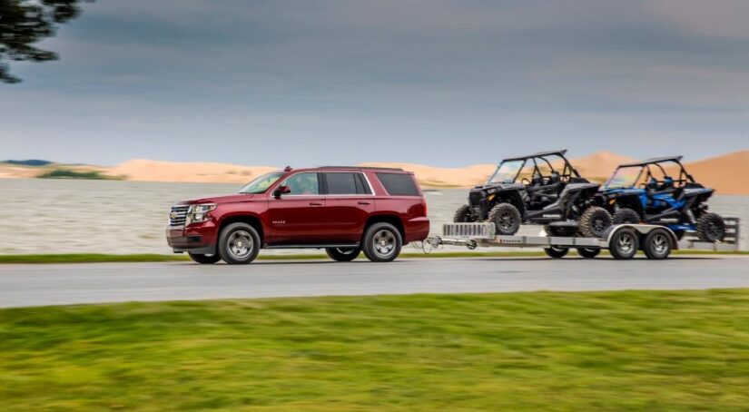A red 2018 Chevy Tahoe for sale towing a trailer.