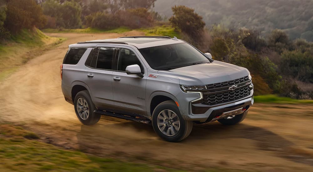 A silver 2023 Chevy Tahoe Z71 driving on a dirt road.
