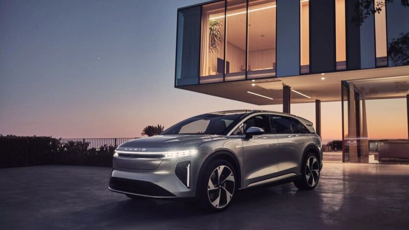 A silver 2025 Lucid Air Gravity parked near a house.