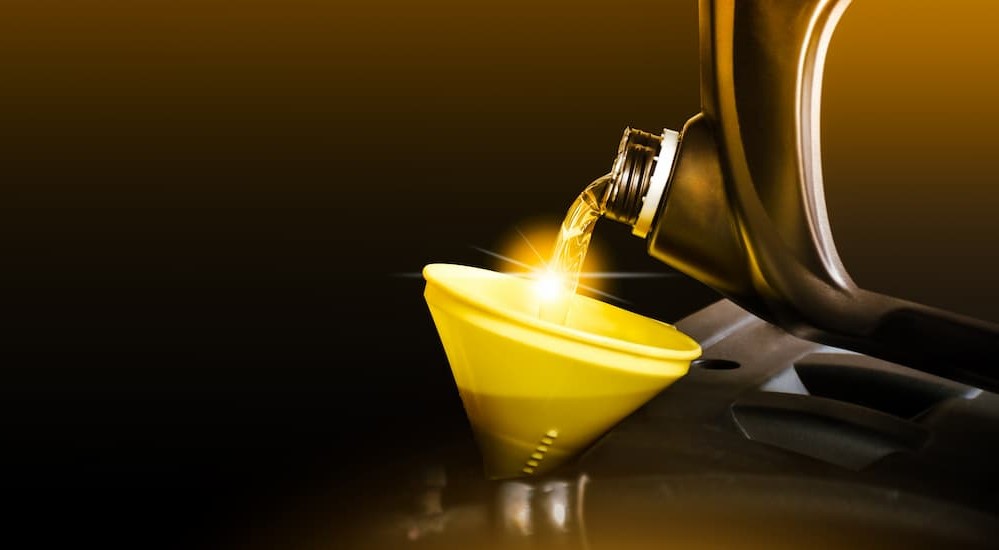 Golden oil poured into a funnel.